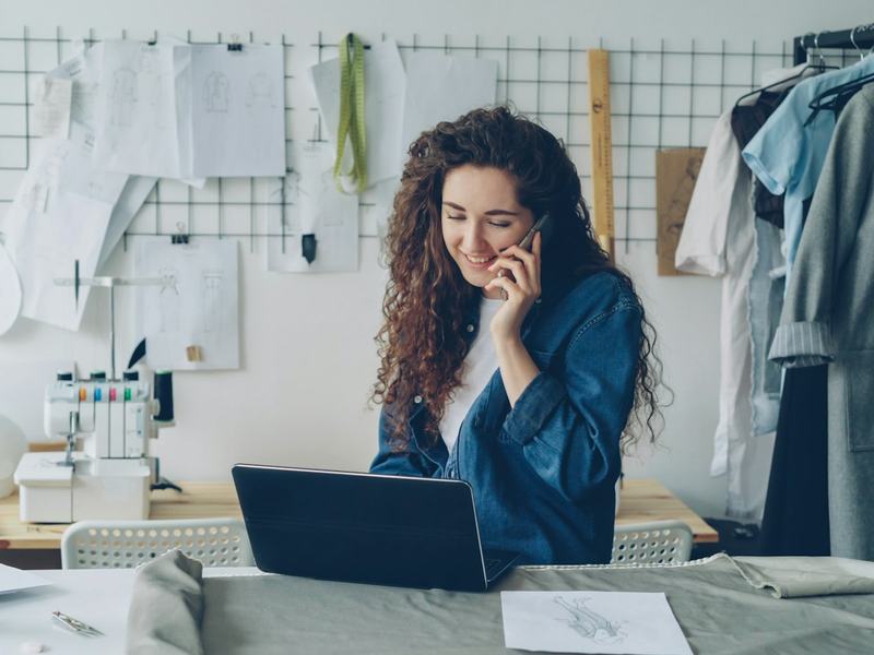 A solo business owner on the phone at her laptop